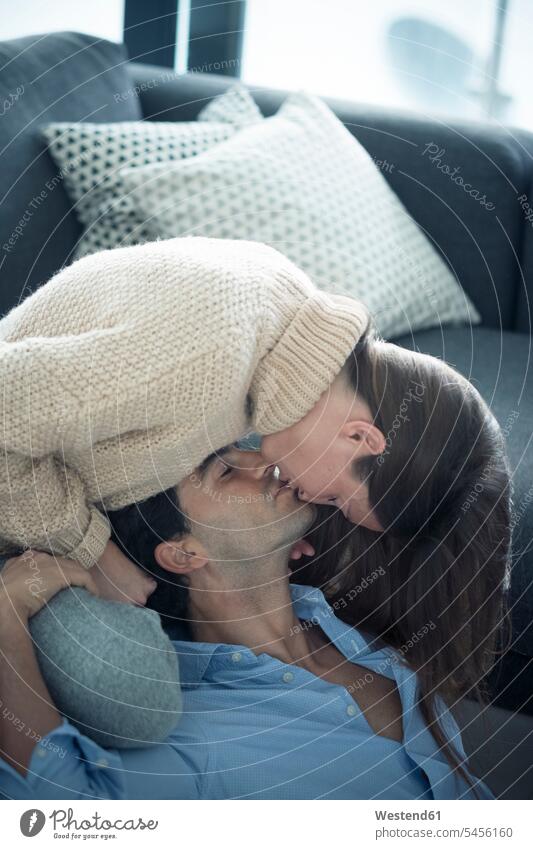 Zu Hause verliebtes junges Paar Pärchen Paare Partnerschaft küssen Küsse Kuss Mensch Menschen Leute People Personen Wohnzimmer Wohnraum Wohnung Wohnen Wohnräume