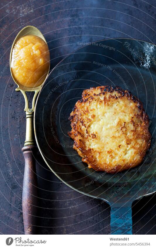 Kartoffelpuffer in der Pfanne und Löffel Apfelmus alt alte altes alter herzhaft Bratpfanne Bratpfannen servierfertig angerichtet Reiberdatschi Reibekuchen Rösti