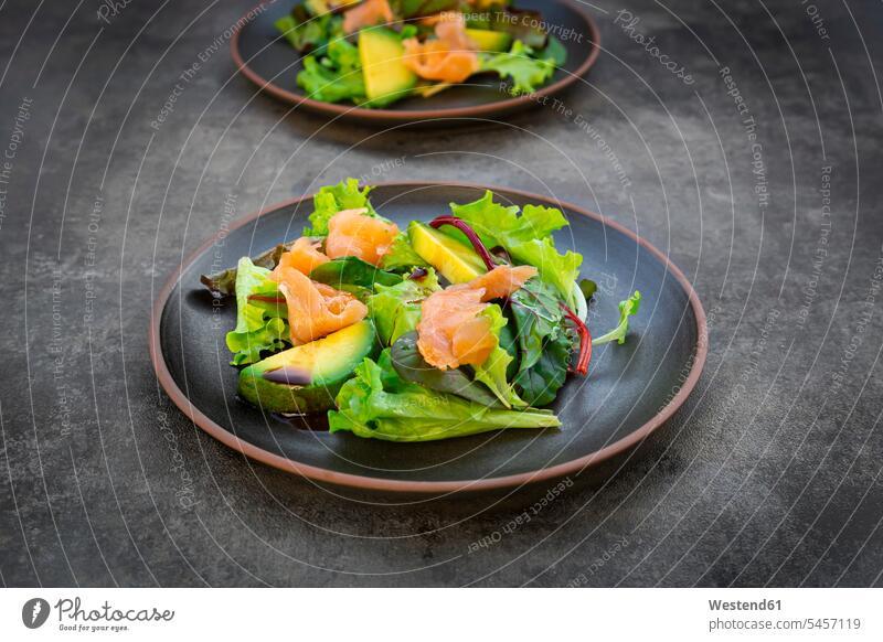 Teller grüner Salat mit Feldsalat, Rucola, Spinat, rotem Blattsalat, Rote-Bete-Blättern, Avocado, Lachsfleisch und Balsamico-Essig Innenaufnahme Innenaufnahmen