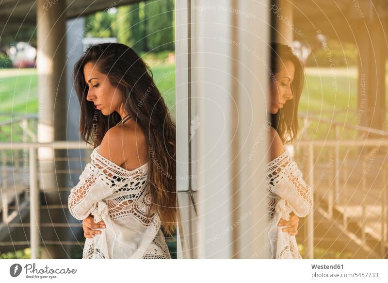 Ernste brünette junge Frau an einem Fenster im Freien weiblich Frauen ernst Ernsthaftigkeit ernsthaft Erwachsener erwachsen Mensch Menschen Leute People