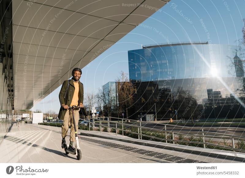 Stilvoller Mann mit Helm auf einem Roller in der Stadt geschäftlich Geschäftsleben Geschäftswelt Geschäftsperson Geschäftspersonen Businessmann Businessmänner