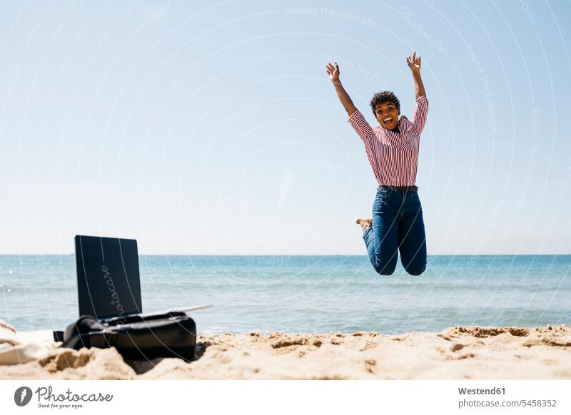 Frau springt am Strand, Laptop auf Tasche Leute Menschen People Person Personen gemischtrassig 1 Ein ein Mensch eine nur eine Person single erwachsen Erwachsene