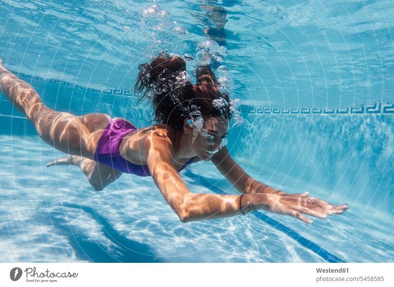 Frau unter Wasser in einem Pool Badebekleidung Badeanzuege Badeanzüge sommerlich Sommerzeit freuen geniessen Genuss leicht Luftblasen Schwimmsport erfrischen
