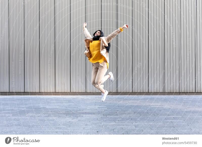 Porträt einer glücklichen jungen Frau, die in die Luft springt Leute Menschen People Person Personen Personen aus dem Nahen Osten 1 Ein ein Mensch