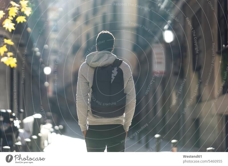 Mann trägt Rucksack, während er mit Händen in den Taschen in der Stadt steht Farbaufnahme Farbe Farbfoto Farbphoto Außenaufnahme außen draußen im Freien Tag
