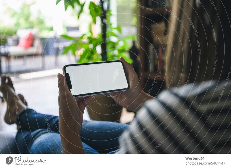 Junge Frau verwendet Smartphone zu Hause Displays sitzend sitzt daheim Eingebung Ideen Technik Technologien mobil Anschluss verbinden verbunden Terrassen