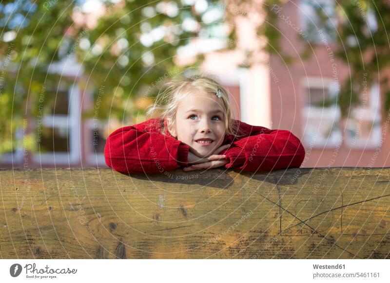 Porträt eines blonden kleinen Mädchens, das an ein Holzgeländer gelehnt ist Geländer blonde Haare blondes Haar hölzern Portrait Porträts Portraits weiblich