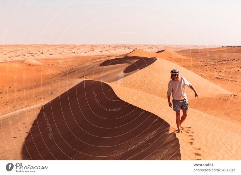 Mann geht auf einer Sanddüne, Wahiba Sands, Oman gehend stehend steht frei auf Achse in Bewegung sandig Landschaften Wüsten Duene Duenen Dünen Sanddünen außen