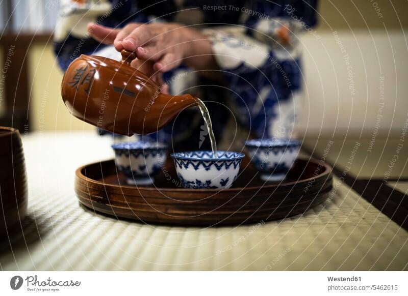 Japan, Hände einer Frau, die während der Teezeremonie Tee in Tassen gießt Innenaufnahme Innenaufnahmen innen drinnen differenzierter Fokus Traditionelle Kultur