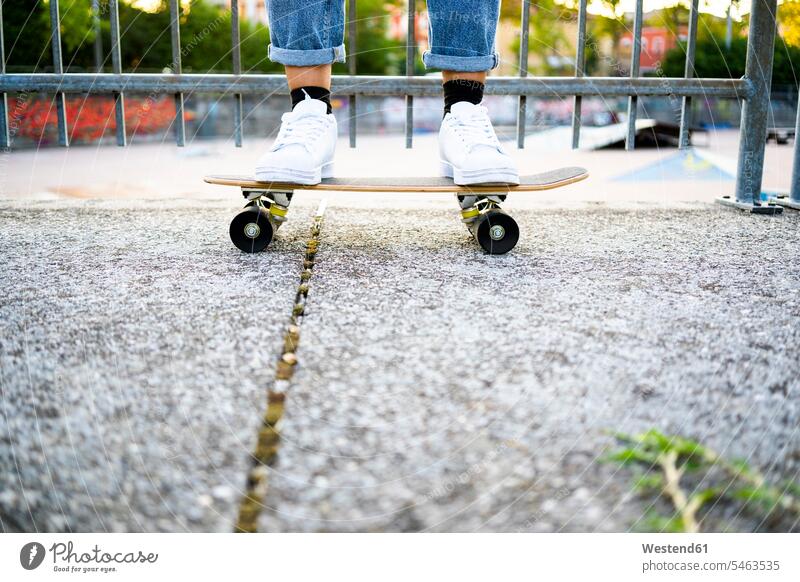 Junge Frau steht auf Skateboard Schuhe weiss weiße weißer weißes stehend Muße Skateboardfahren Skateboarding auf Achse in Bewegung Travel Parkanlage Parkanlagen
