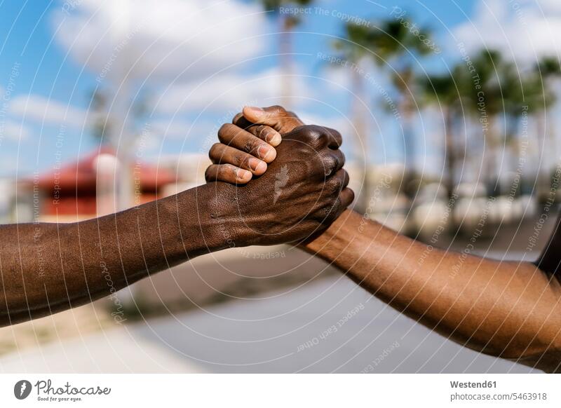 Junge Männer schütteln Hände auf dem Basketballplatz Leute Menschen People Person Personen Afrikanisch Afrikanische Abstammung dunkelhäutig Farbige Farbiger