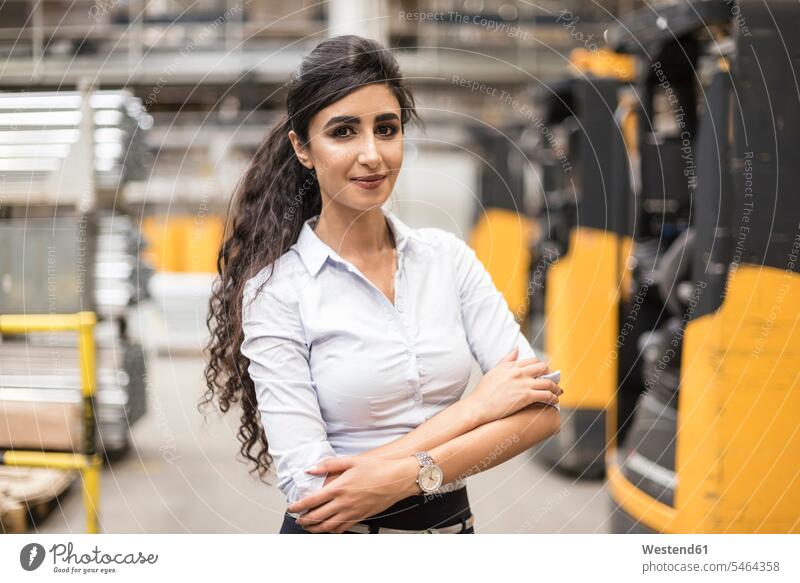 Porträt einer selbstbewussten Frau in einer Fabrikhalle Portrait Porträts Portraits weiblich Frauen Industriehallen Fabrikhallen Fabriken Erwachsener erwachsen