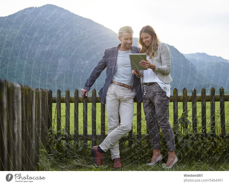 Mann und Frau teilen sich Tabletten in ländlicher Landschaft Teilen Sharing Tablet Computer Tablet-PC Tablet PC iPad Tablet-Computer Aussicht Ausblick Ansicht