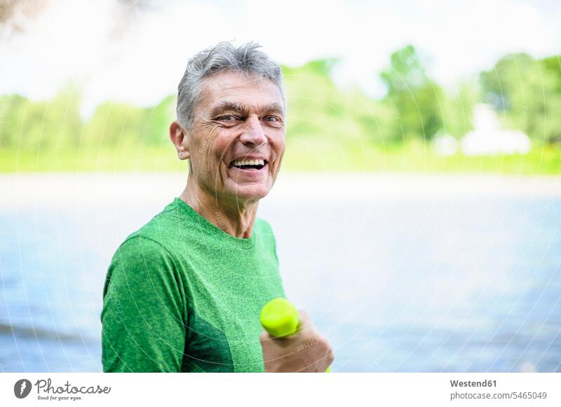 Porträt eines lächelnden, aktiven älteren Mannes, der im Park Sport treibt, in Seitenansicht Farbaufnahme Farbe Farbfoto Farbphoto Außenaufnahme außen draußen