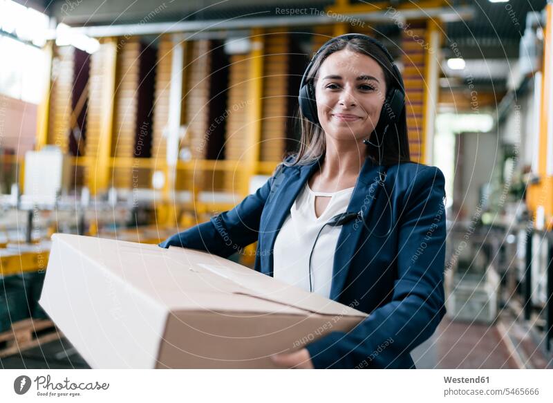 Junge Frau arbeitet beim Paketdienst, trägt Paket im Lager Pakete Päckchen Angestellte Mitarbeiterin Kurierdienst Expressdienst Postdienst Depot tragen