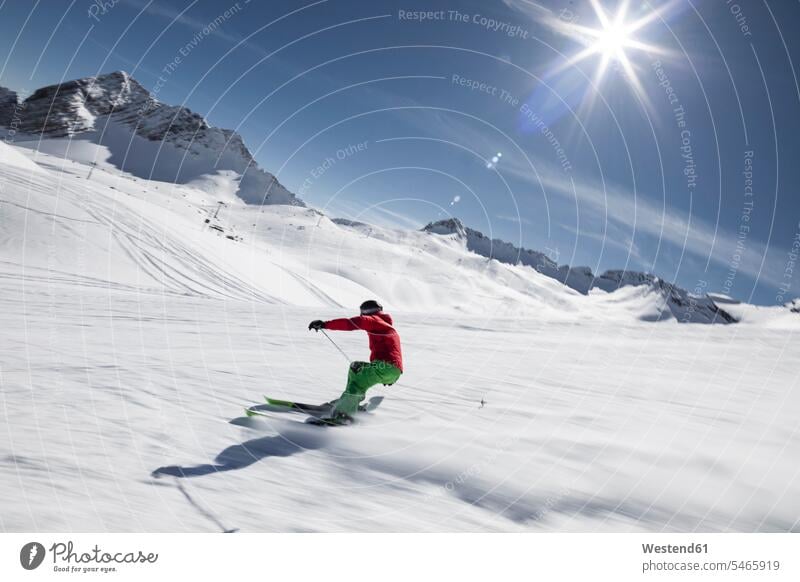 Deutschland, Bayern, Garmisch-Partenkirchen, Sonne scheint über Mann beim Skifahren auf der Zugspitze Außenaufnahme außen draußen im Freien Tag