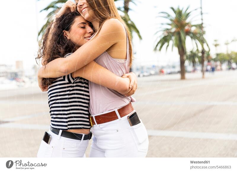 Zwei Glückliche Freundinnen Umarmen Und Umarmen Sich Auf Der Promenade Mit Palmen Ein 