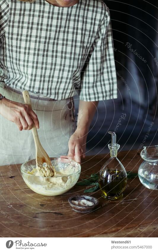 Junge Frau in der Küche bereitet Teig für frischen Kichererbsenkuchen vor Cicer arietinum Mehl rühren ruehren umruehren umrühren zubereiten kochen