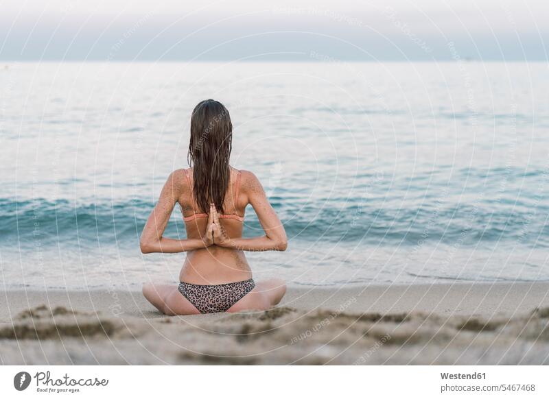 Schöne Frau am Strand beim Yoga praktizieren Bikini Bikinis nasse Haare Meer Meere Beach Straende Strände Beaches schöne Frau schöne Frauen üben ausüben Übung