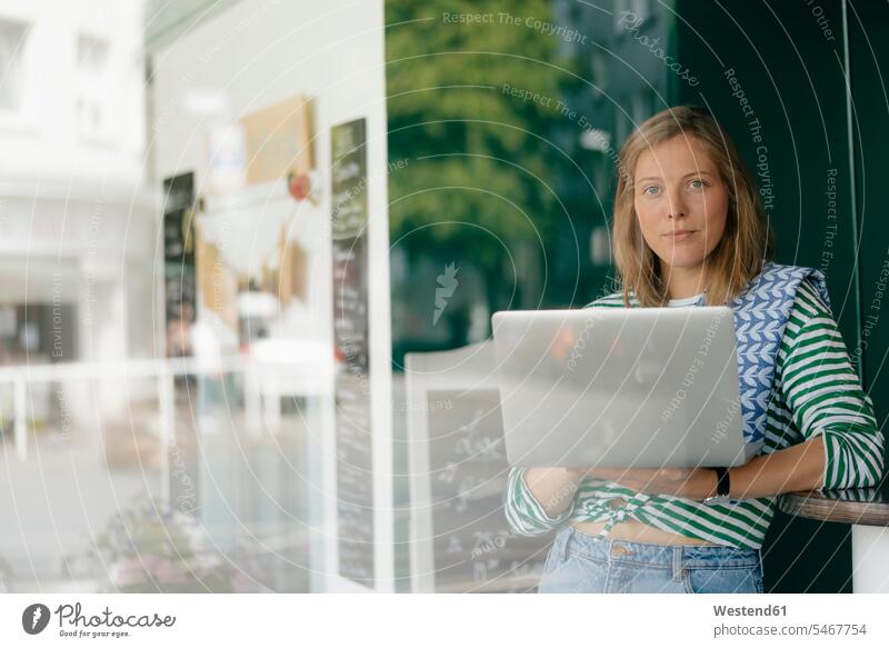 Porträt einer jungen Frau mit Laptop in einem Café weiblich Frauen Cafe Kaffeehaus Bistro Cafes Cafés Kaffeehäuser Portrait Porträts Portraits Notebook Laptops