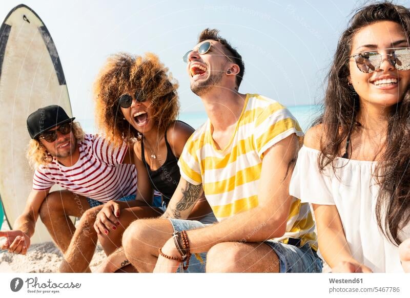 Freunde sitzen am Strand und haben Spaß sitzend sitzt Spass Späße spassig Spässe spaßig Gemeinsam Zusammen Miteinander Surfbrett Surfbretter surfboard