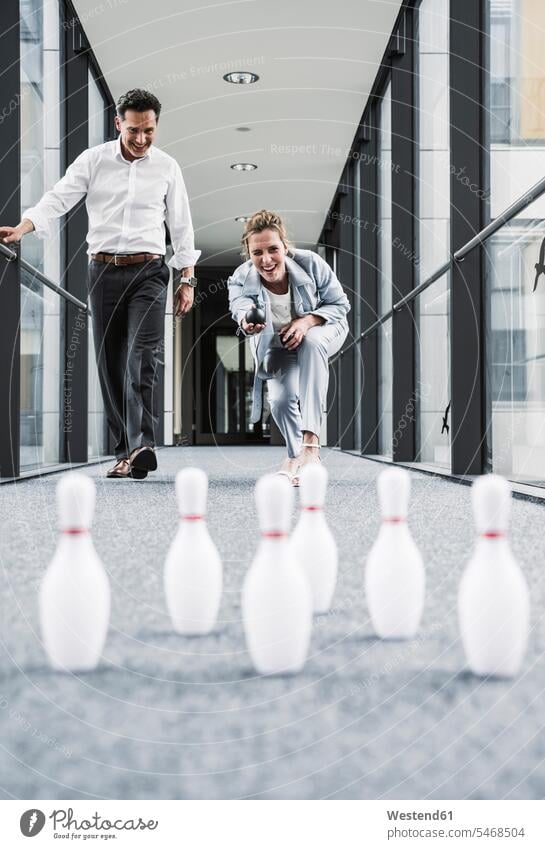 Glücklicher Geschäftsmann und Geschäftsmann beim Kegeln im Bürodurchgang Office Büros Geschäftsfrau Geschäftsfrauen Businesswomen Businessfrauen Businesswoman