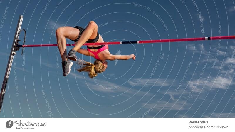 Weiblicher Hochspringer, Ansicht aus der Froschperspektive springen hüpfen Sprung Spruenge Sprünge Sportlerin Sportlerinnen Leichtathletin Athletin