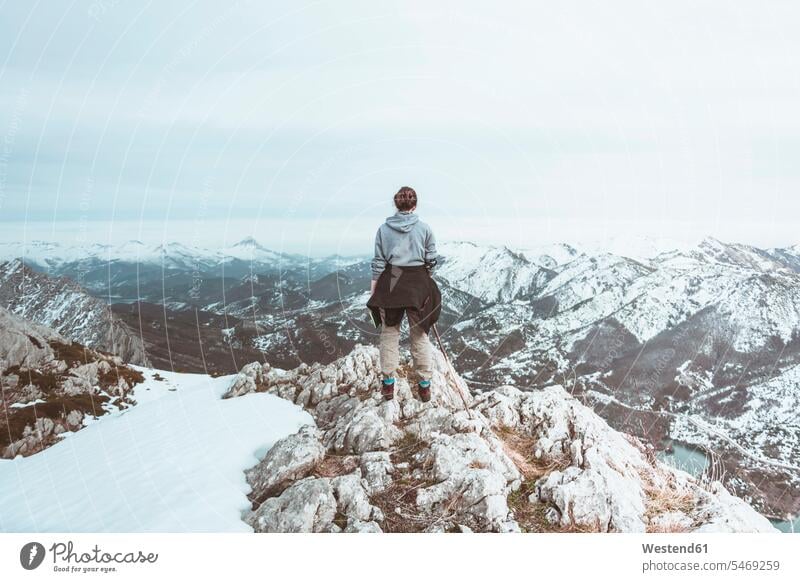 Rückenansicht einer jungen Frau, die auf einem Berggipfel steht und auf die Aussicht schaut, Provinz León, Spanien entspannen relaxen Wanderung geniessen Genuss