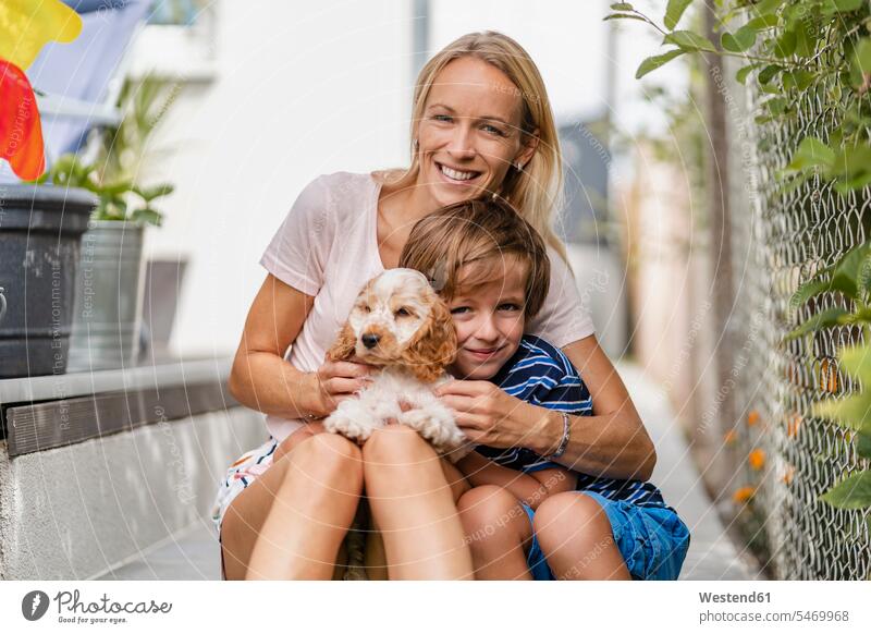 Porträt von Mutter und Sohn beim Kuscheln mit süßem Hundewelpen Tiere Tierwelt Jungtiere Tierbabies Tierbaby Welfe Welfen Welpen T-Shirts knuddeln schmusen