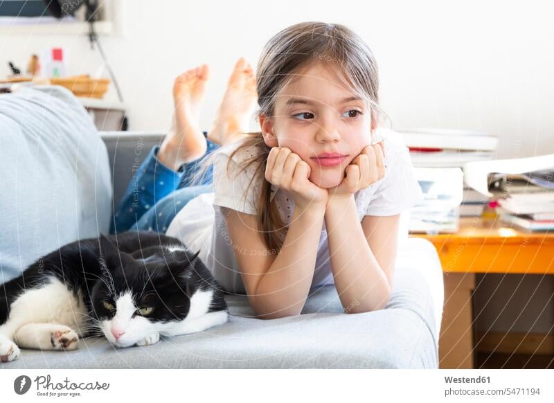 Porträt des kleinen Mädchens auf der Couch liegend mit Katze Katzen Portrait Porträts Portraits Sofa Couches Liege Sofas weiblich liegt Haustier Haustiere Tier