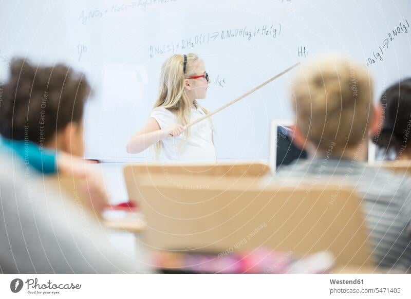 Schulmädchen erklärt Formel am Whiteboard in der Klasse Formeln Schülerin Schuelerin Schülerinnen Schuelerinnen erklären erklaeren Schule Schulen Schulklasse