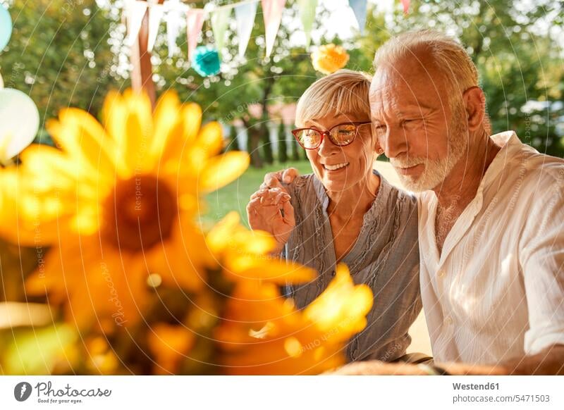 Glückliches älteres Paar umarmt auf einer Gartenparty Feier Fest Festlichkeit Feiern Festlichkeiten Feste glücklich glücklich sein glücklichsein Gartenpartys