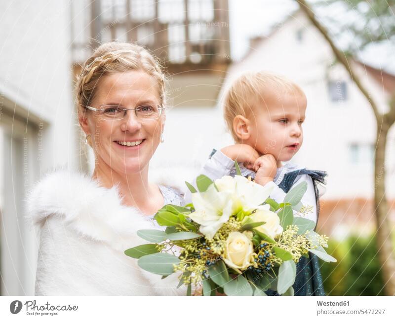 Porträt der glücklichen Braut mit kleinem Mädchen und Brautstrauß Bräute weiblich Portrait Porträts Portraits Glück glücklich sein glücklichsein Brauststrauss