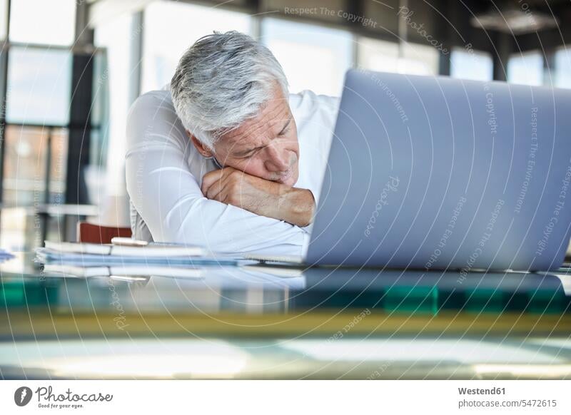 Erschöpfter Geschäftsmann schläft vor dem Laptop Büro Office Büros Laptop benutzen Laptop benützen arbeiten Arbeit schlafen schlafend Businessmann