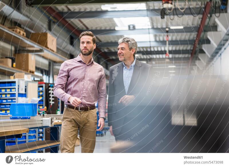 Geschäftsleute beim Treffen in der Produktionshalle Mann Männer männlich Businessmann Besprechung besprechen diskutieren Fabrik Fabriken Erwachsener erwachsen