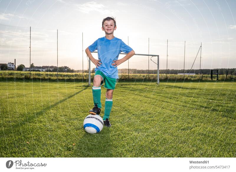 Porträt eines selbstbewussten jungen Fussballspielers mit Ball auf dem Fussballplatz Fußballspieler Fussballer Fußballer Junge Buben Knabe Jungen Knaben