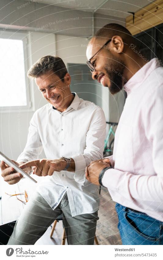 Zwei lächelnde Geschäftsleute mit Tabletten haben ein Treffen im Loft Büro Lofts besprechen diskutieren Besprechung Tablet Computer Tablet-PC Tablet PC iPad