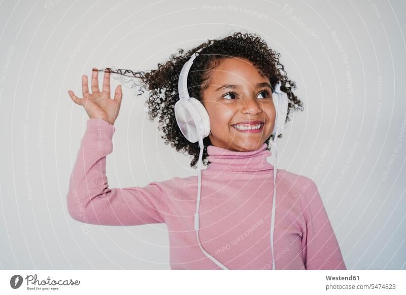 Porträt eines lächelnden kleinen Mädchens, das mit Kopfhörern Musik hört Leute Menschen People Person Personen 1 Ein ein Mensch nur eine Person single Kids