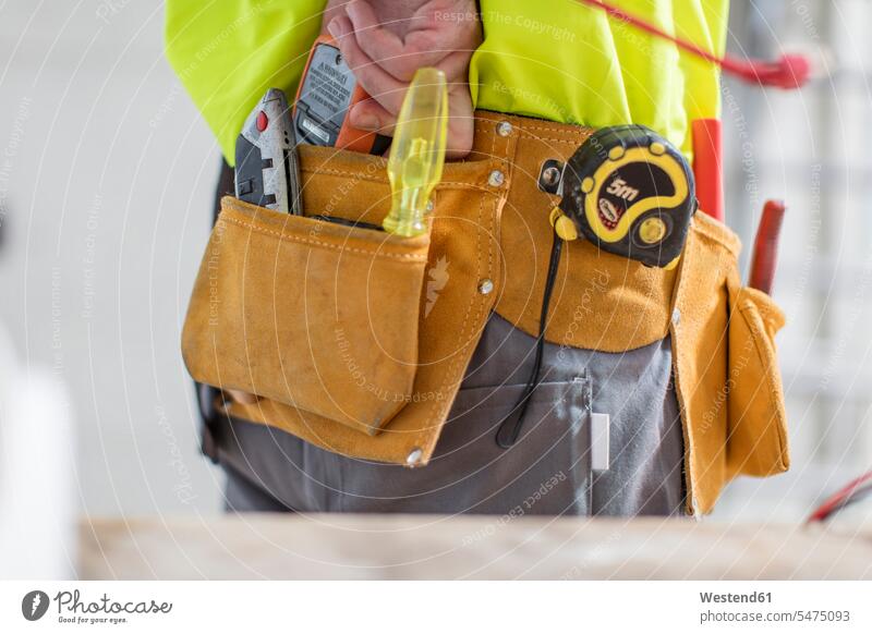 Nahaufnahme eines Bauarbeiters mit Werkzeuggürtel Werkzeuge arbeiten Arbeit Gerät Geräte Handwerker Handwerksberuf Handwerksberufe Gewerbe Innenaufnahme drinnen