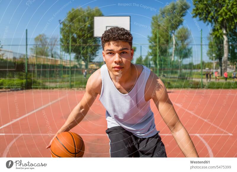 Junger Mann spielt Basketball Basketballspiel Basketbaelle Basketbälle spielen Sportplatz Sportplaetze Sportplätze Bewegung sich bewegen Vitalität Elan Schwung