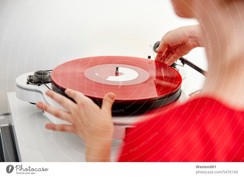 Frau legt rote Schallplatte auf Plattenspieler platzieren aufsetzen plazieren auflegen roter rotes Vinyl Schallplatten weiblich Frauen Farbe Farbtöne Farbtoene
