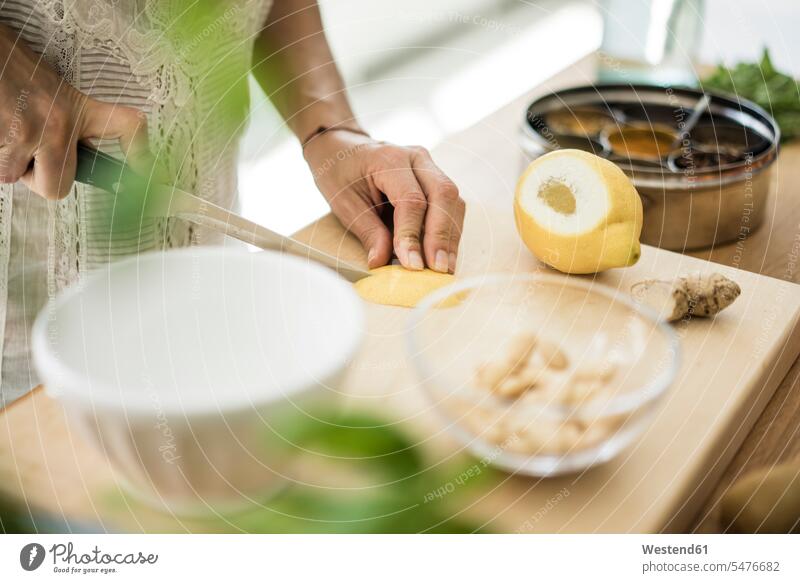 Frau bereitet gesundes Essen in ihrer Küche zu Obst Früchte zubereiten kochen Essen zubereiten Zitronenschale schneiden abschneiden kleinschneiden Food