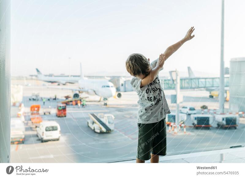 Spanien, Flughafen Barcelona, Junge im Abflugbereich, der vorgibt, zu fliegen Europäer Kaukasier Europäisch kaukasisch Tourist Touristen Reise Travel warten