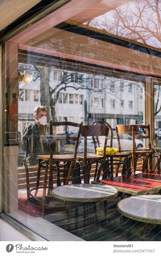 Mann mit Maske schaut durch Fenster in geschlossenes Restaurant Leute Menschen People Person Personen Europäisch Kaukasier kaukasisch 1 Ein ein Mensch eine