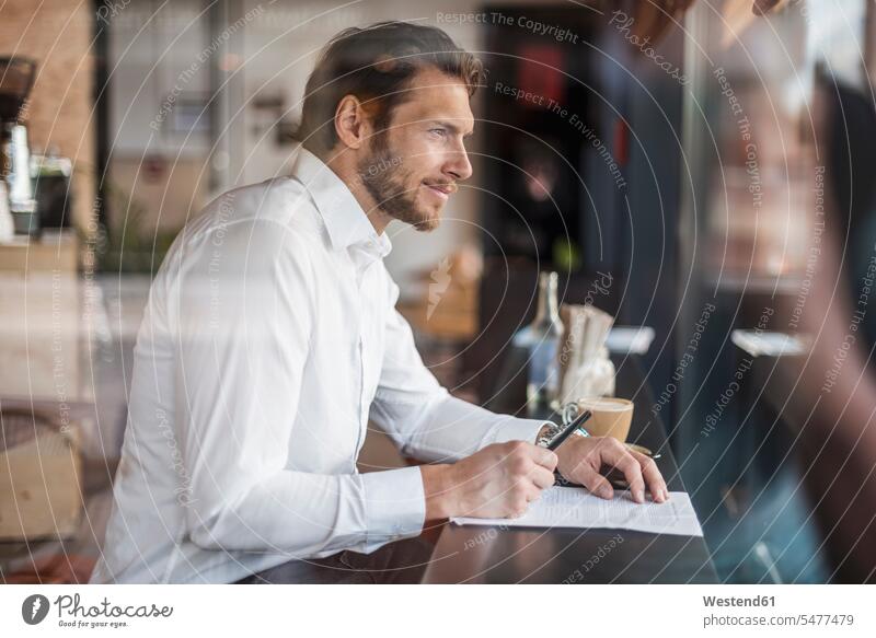 Geschäftsmann in einem Café macht sich Notizen notieren Cafe Kaffeehaus Bistro Cafes Cafés Kaffeehäuser Businessmann Businessmänner Geschäftsmänner Gastronomie