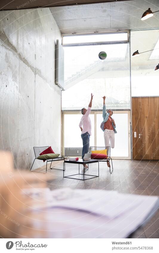 Lässiger Geschäftsmann und Geschäftsfrau spielen Basketball in einem Loft Geschäftsfrauen Businesswomen Businessfrauen Businesswoman Businessmann Businessmänner