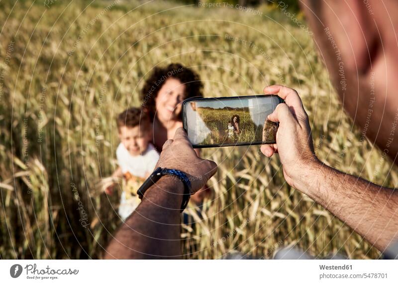 Nahaufnahme eines Mannes, der Mutter und Sohn mit einem Smartphone auf einem Bauernhof fotografiert Farbaufnahme Farbe Farbfoto Farbphoto Spanien
