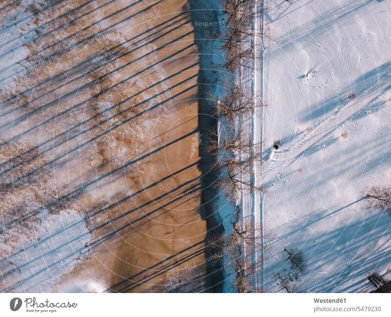 Russland, Oblast Leningrad, Tichwin, Luftaufnahme einer schneebedeckten Straße entlang eines zugefrorenen Teiches Außenaufnahme außen draußen im Freien Tag