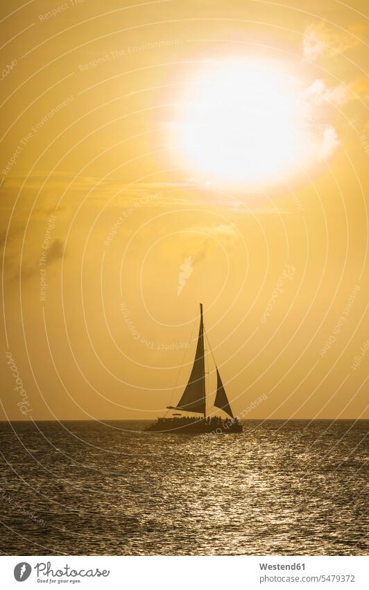 Karibik, Aruba, Segelboot auf dem Meer bei Sonnenuntergang Abendstimmung Aussicht Ausblick Ansicht Überblick Segelboote Segelschiff Himmel Reise Travel Meere