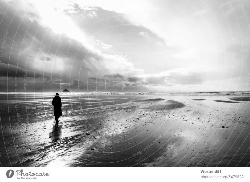 Frankreich, Bretagne, Finistere, Halbinsel Crozon, Frau beim Strandspaziergang Sonne Außenaufnahme draußen im Freien Der Weg nach vorne Gegenlicht